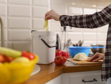 vrouw die bokashi compost maakt in de keuken