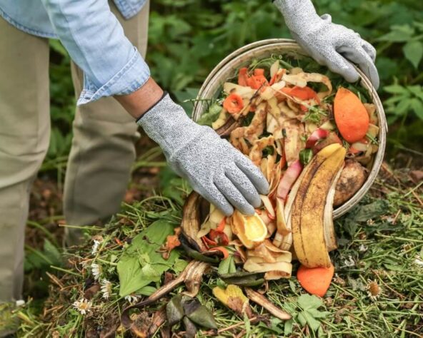 Iemand gooit fruit- en groenteschillen in de tuin