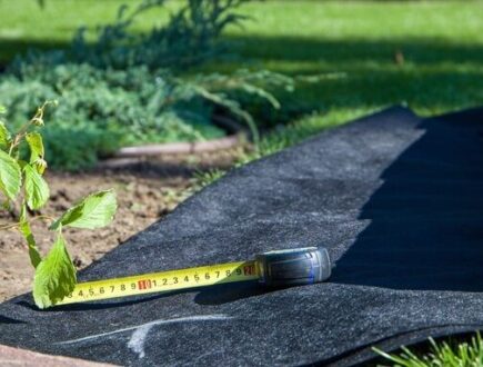 Worteldoek en meetlint op tuinbodem