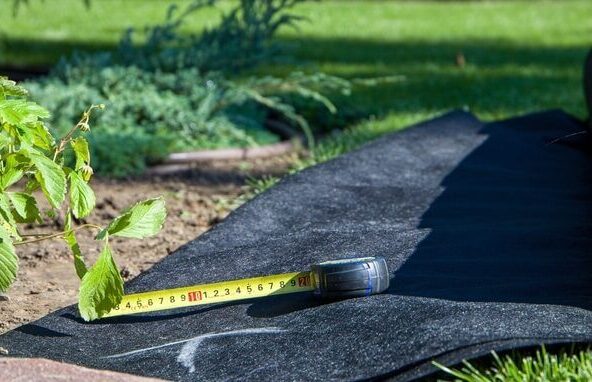 Worteldoek en meetlint op tuinbodem