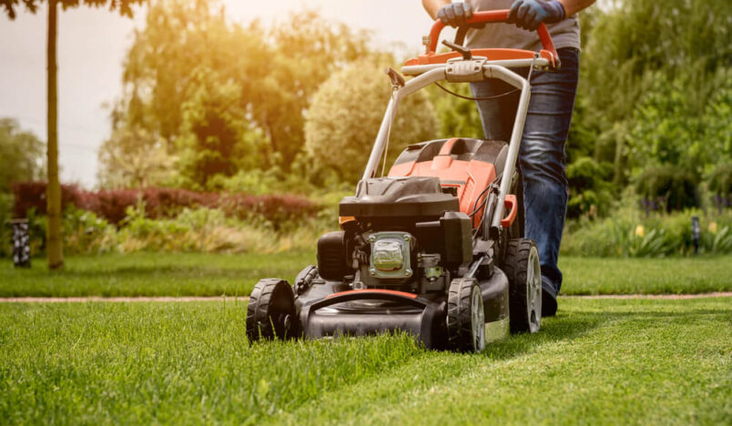 Iemand maait gazon met grasmaaier
